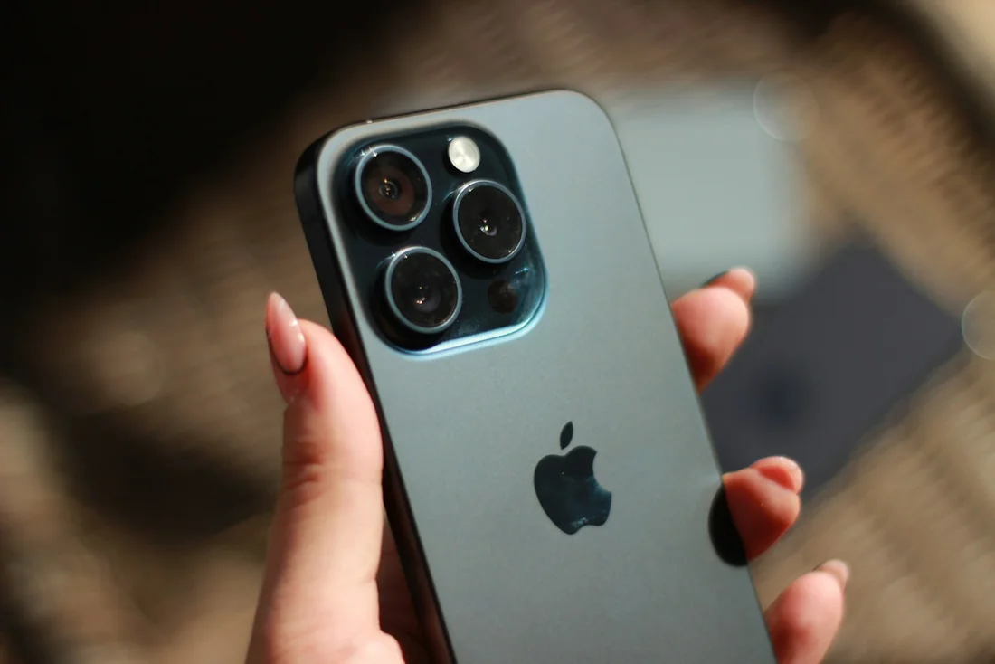 Pessoa segurando um iPhone, com destaque para a parte traseira do aparelho